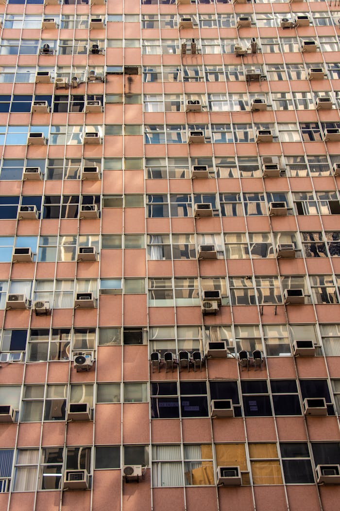 Crafting Captivating Headlines: Your awesome post title goes here Vertical shot of a building facade covered with windows and air conditioning units.